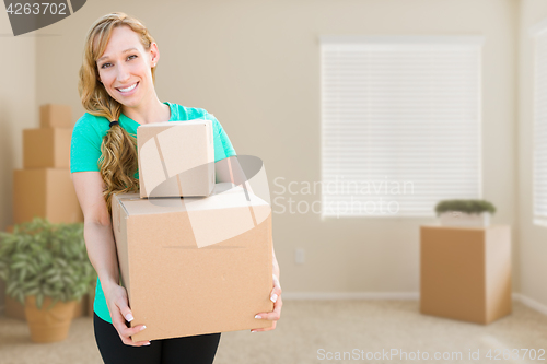 Image of Happy Young Adult Woman Holding Moving Boxes In Empty Room In A 