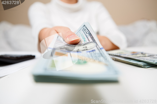 Image of Hands of person proposing money to you - closeup shot