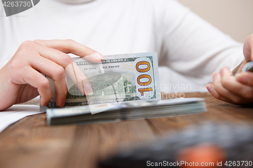 Image of Hands hold and counting us dollar banknotes