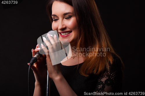 Image of Brunette with microphone in hands