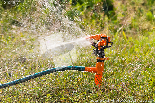 Image of garden sprinkler spraying water over lawn