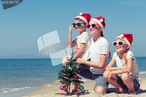 Image of Three happy children  playing on the beach at the day time.