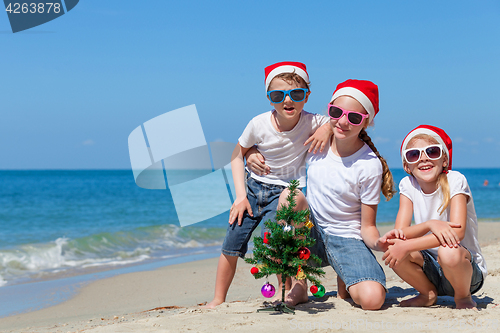 Image of Three happy children  playing on the beach at the day time. 