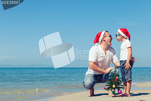 Image of Father and son playing on the beach at the day time.