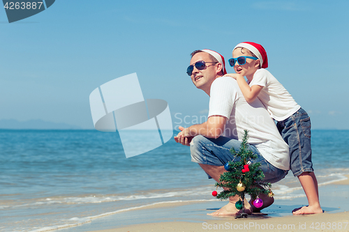 Image of Father and son playing on the beach at the day time.