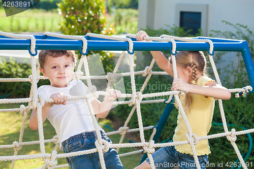 Image of happy brother and sister playing on the playground