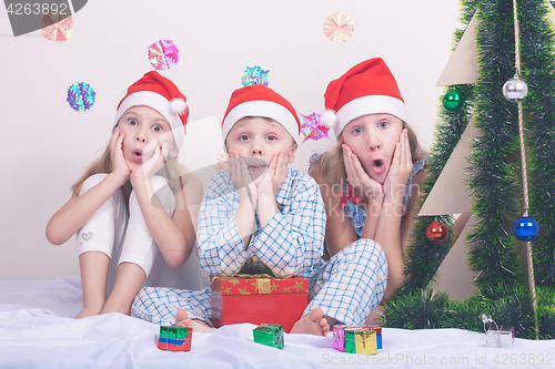 Image of Happy little smiling boy and girls with christmas hat.