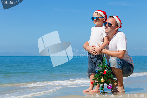 Image of Father and son playing on the beach at the day time.