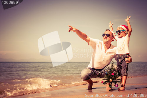 Image of Father and son playing on the beach at the day time.