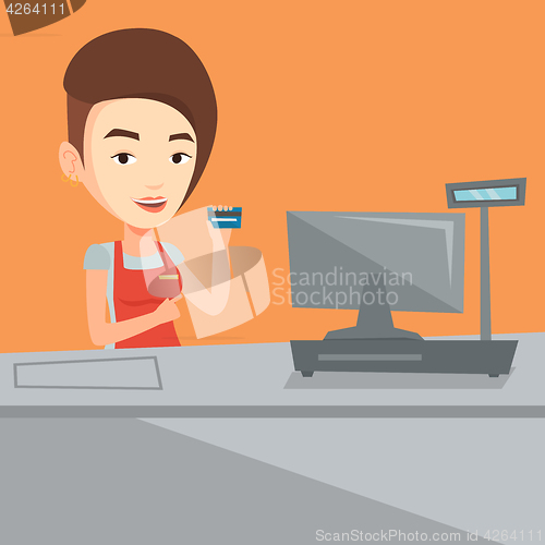 Image of Cashier holding credit card at the checkout.