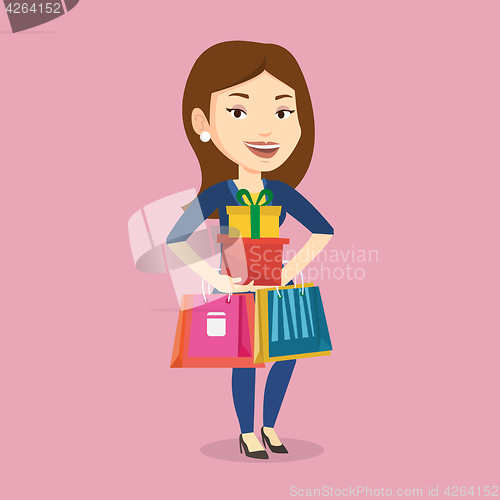 Image of Happy woman holding shopping bags and gift boxes.