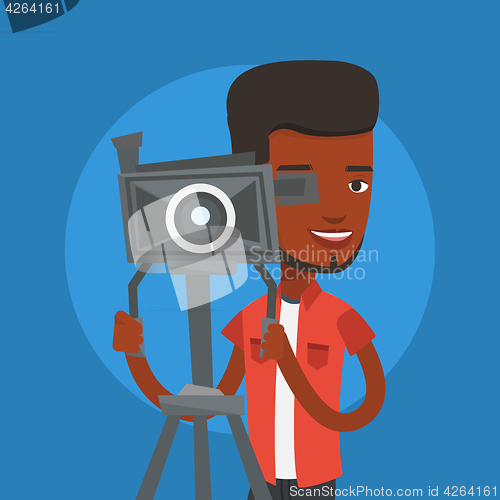 Image of Cameraman with movie camera on tripod.