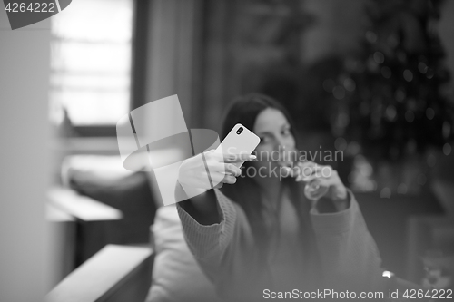 Image of woman drinking doing selfy at spa