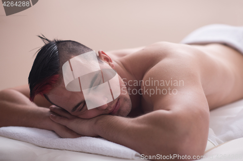 Image of handsome man resting in a spa massage center