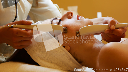 Image of Cosmetology. Beautiful Woman At Spa Clinic Receiving Stimulating Electric Facial Treatment From Therapist. Closeup Of Young Female Face During Microcurrent Therapy. Beauty Treatment.