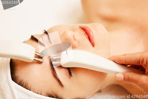 Image of Cosmetology. Beautiful Woman At Spa Clinic Receiving Stimulating Electric Facial Treatment From Therapist. Closeup Of Young Female Face During Microcurrent Therapy. Beauty Treatment.