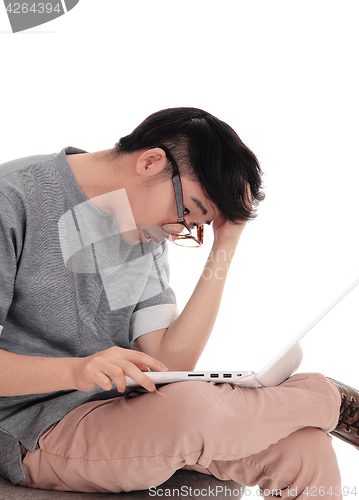 Image of Asian man working at laptop.