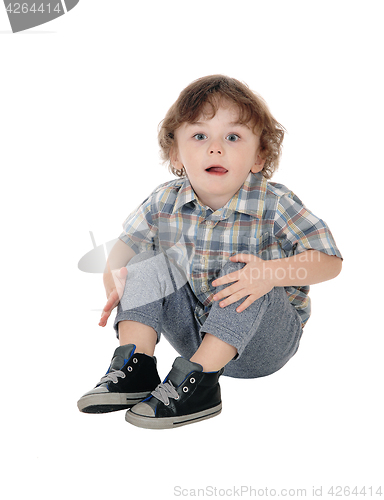 Image of Little three year boy sitting on floor.