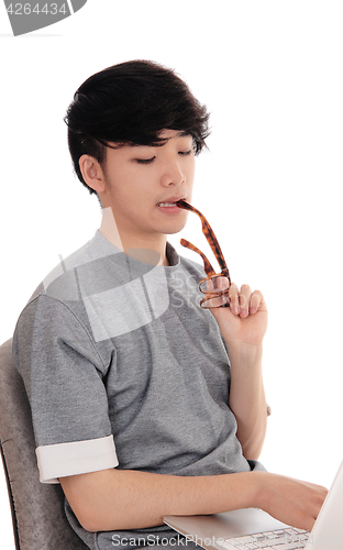 Image of Young man working at laptop.