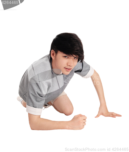 Image of Asian man kneeling on floor.
