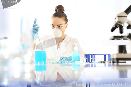 Image of Research. Chemist examine the sample under a microscope.