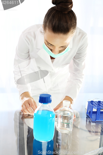 Image of Chemist examine the sample under a microscope.