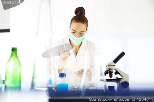 Image of Chemist examine the sample under a microscope. Research laboratory. Chemical experiments. Engineering.