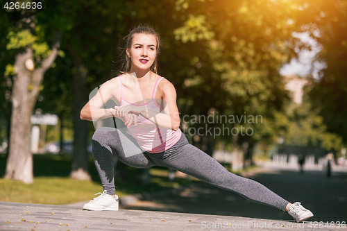 Image of Fit fitness woman doing stretching exercises outdoors at park