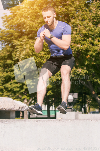 Image of Fit man doing exercises outdoors at park