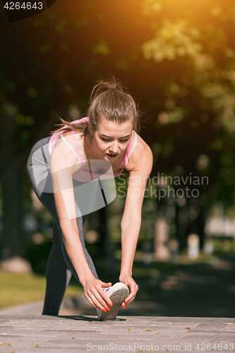 Image of Fit fitness woman doing stretching exercises outdoors at park