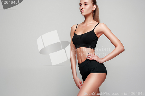 Image of Muscular young woman athlete on gray