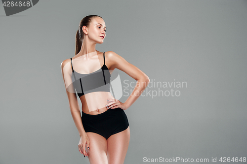Image of Muscular young woman athlete on gray