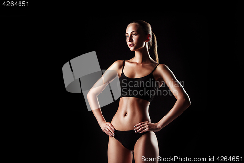 Image of Muscular young woman athlete on black