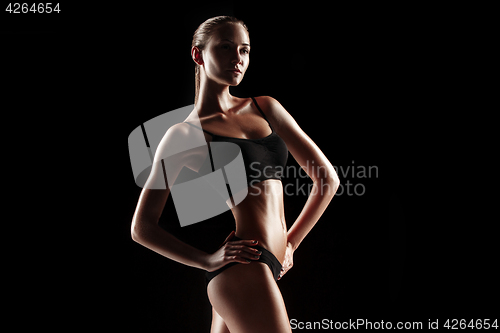 Image of Muscular young woman athlete on gray