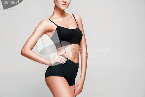 Image of Muscular young woman athlete on gray