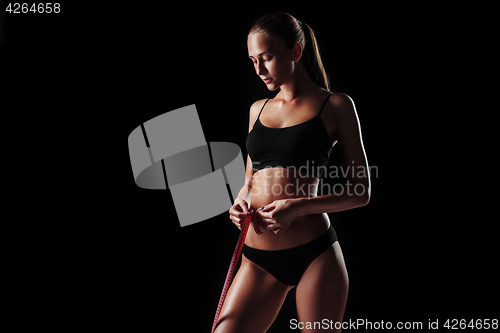 Image of The fit woman measuring perfect shape of beautiful body. Healthy lifestyles concept