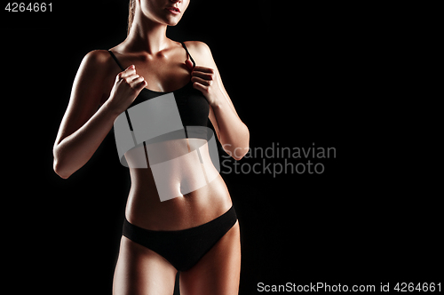 Image of Muscular young woman athlete on black