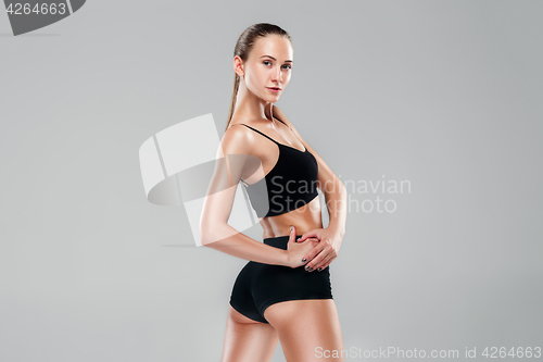 Image of Muscular young woman athlete on gray