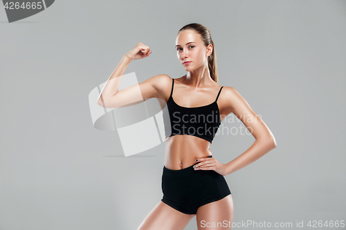 Image of Muscular young woman athlete on gray