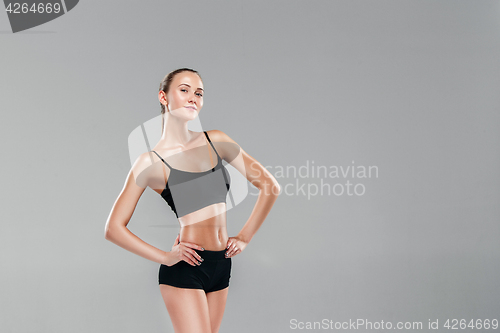 Image of Muscular young woman athlete on gray