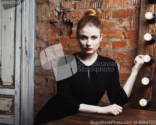 Image of young stylish woman in make up room with mirror, diva actress before perfomance thinking art. loft interior