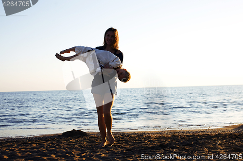 Image of young mother with son resting on sea coast, happy family togethe