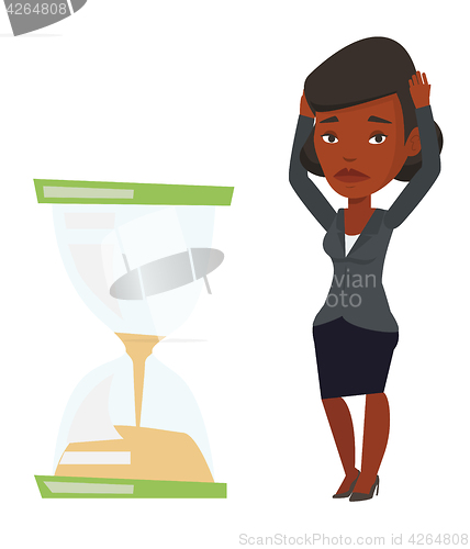 Image of Desperate businesswoman looking at hourglass.