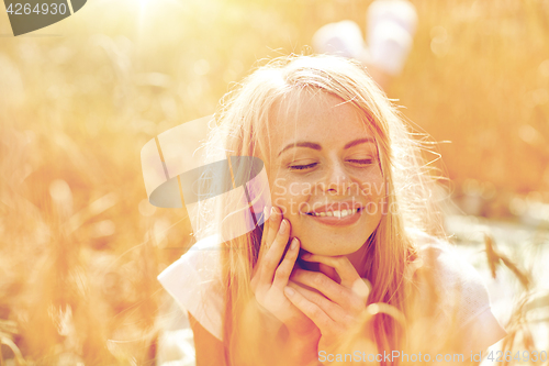 Image of happy woman or teen girl lying in cereal field