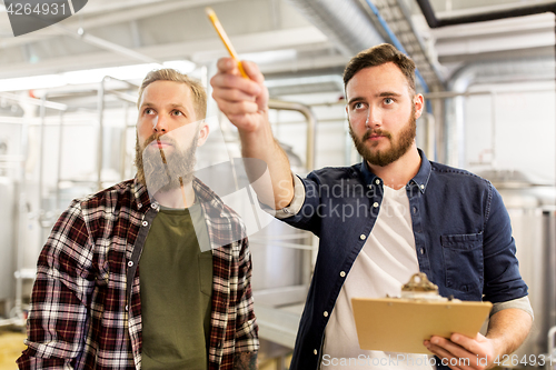 Image of men with clipboard at craft brewery or beer plant