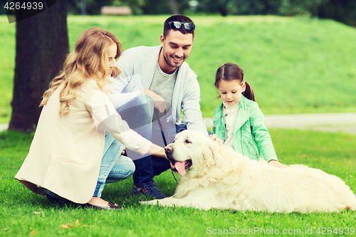 Image of happy family with labrador retriever dog in park