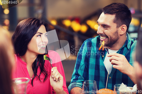 Image of happy friends having dinner at restaurant