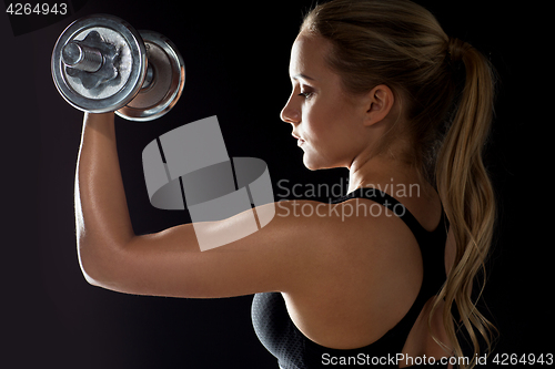 Image of young sporty woman exercising with dumbbell