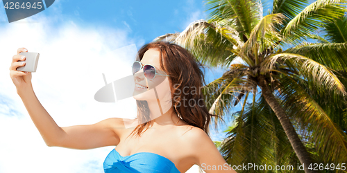 Image of woman in swimsuit taking selfie with smatphone