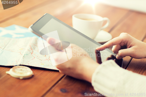 Image of close up of traveler hands with tablet pc and map